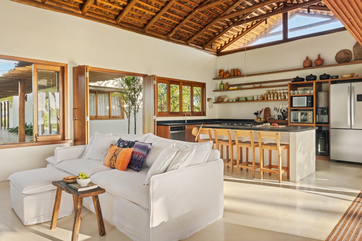 Sala de estar com sofá branco e teto de madeira